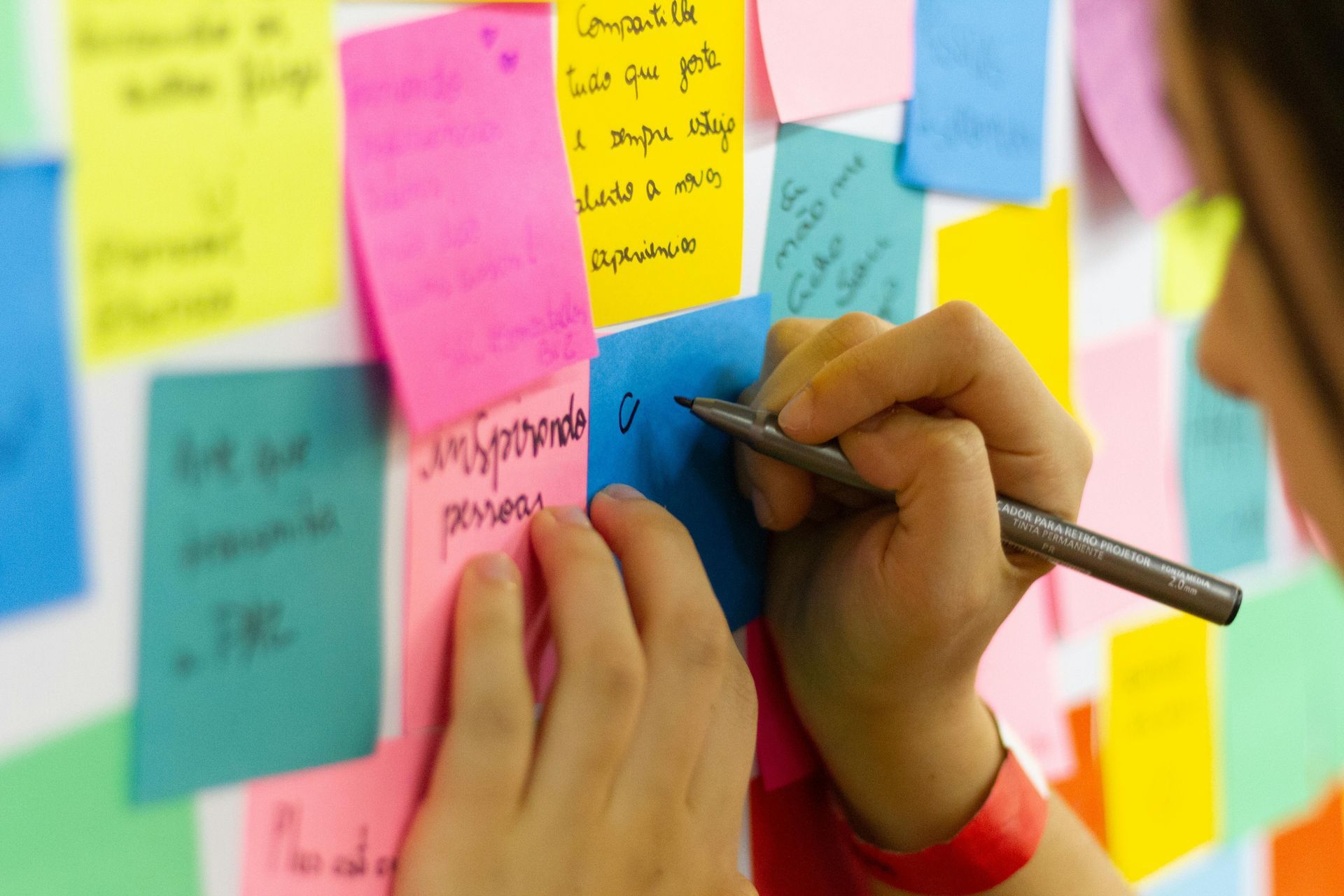 someone making sticky notes trying to break down a big task into smaller tasks