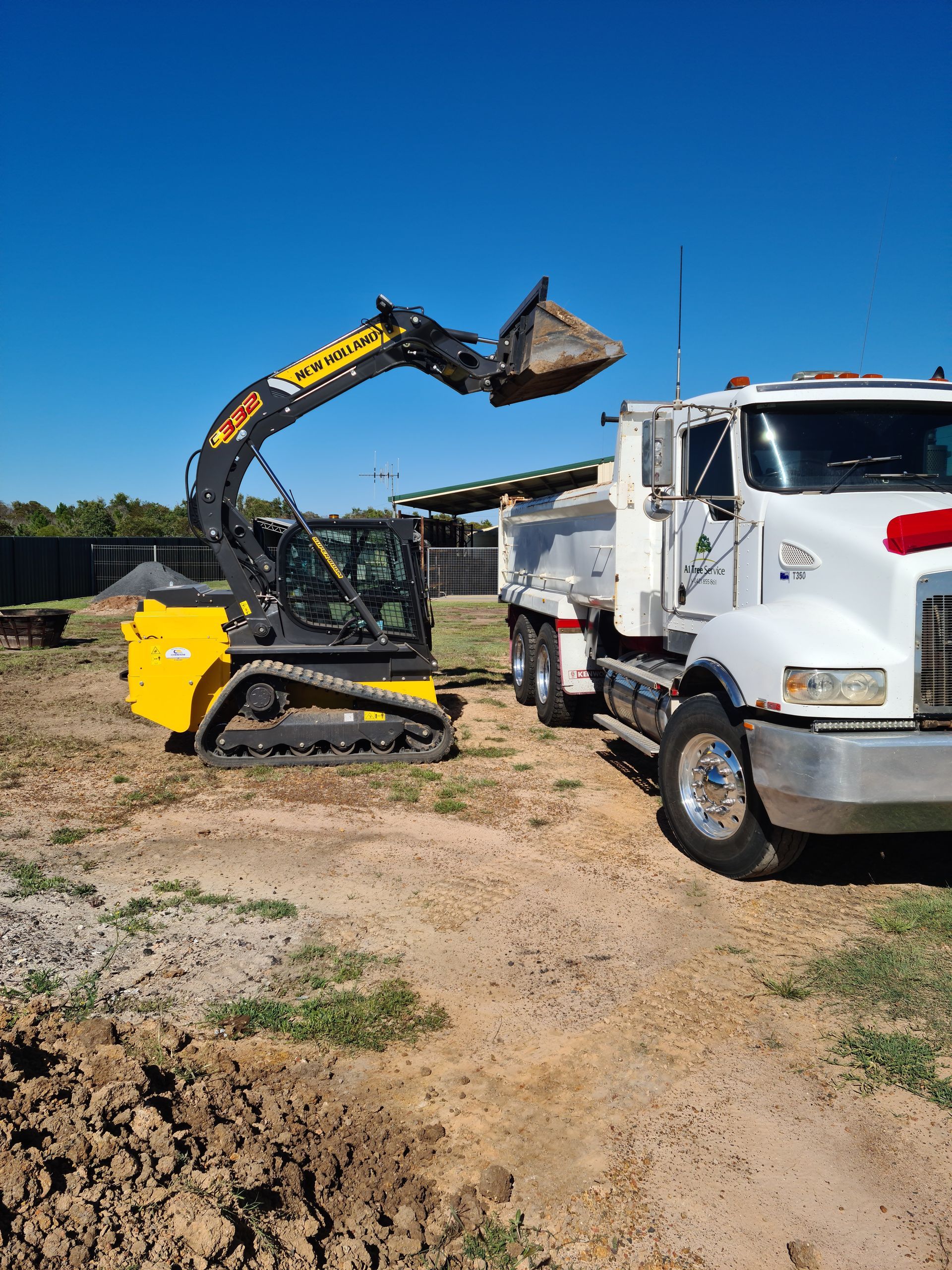 Yellow Excavator Loading Dirt Into White Truck — A1 Tree Service in Kensington, QLD
