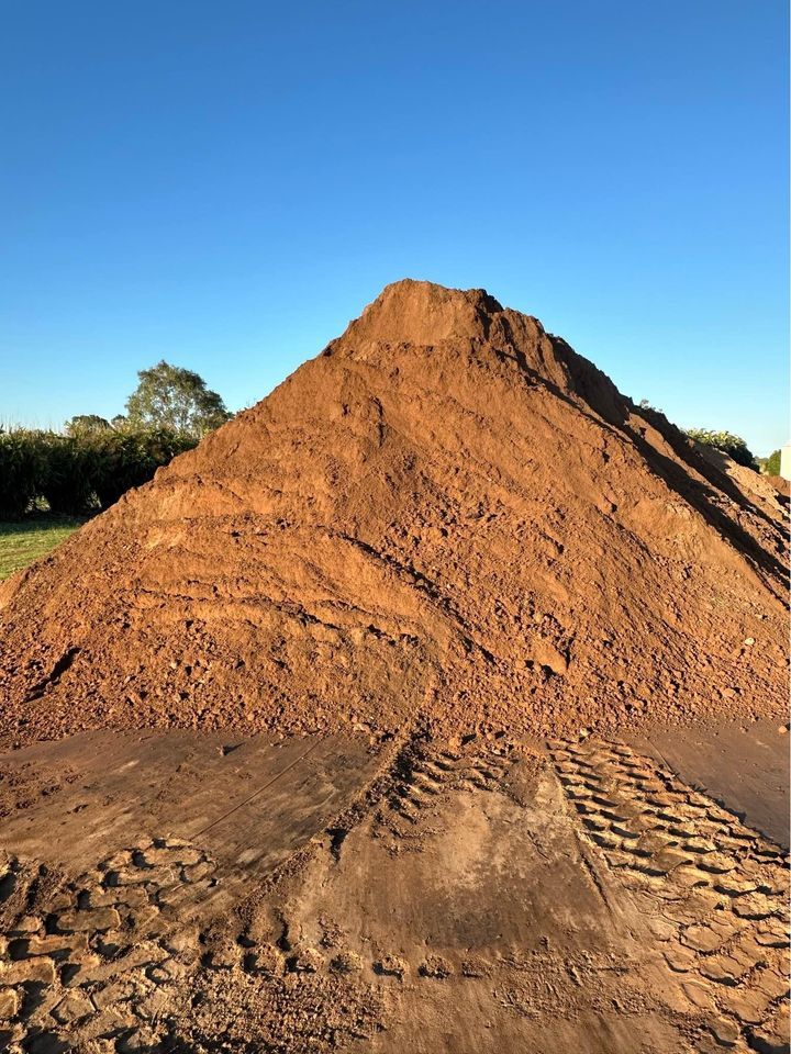 A Dump Truck Is Being Loaded with A Large Pile of Dirt — A1 Tree Service in Childers, QLD