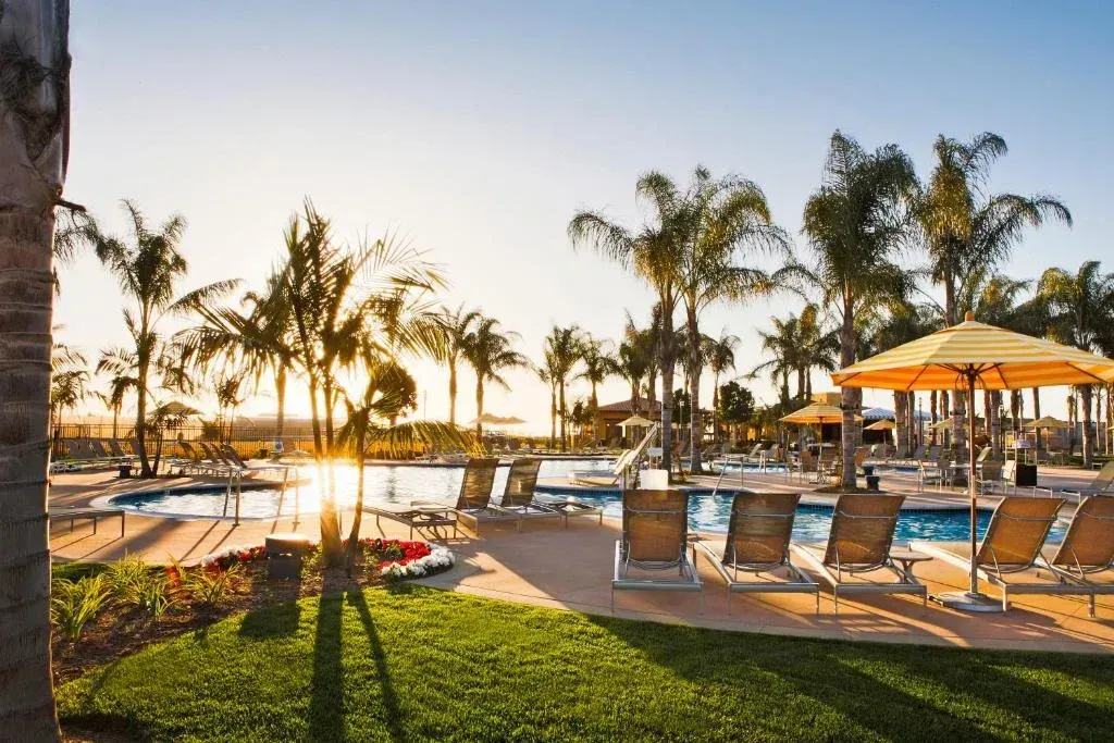 a large swimming pool surrounded by chairs and umbrellas
