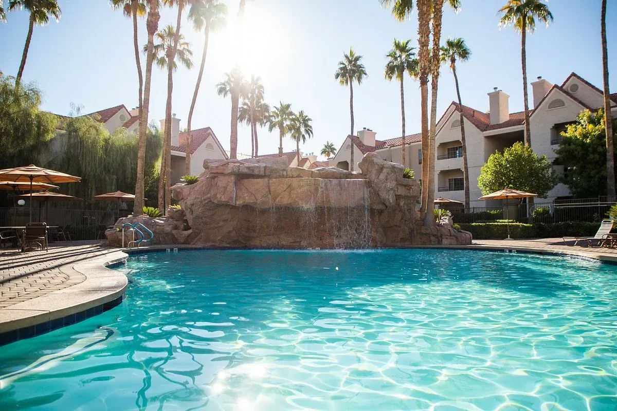 a large swimming pool with a waterfall in the middle of it