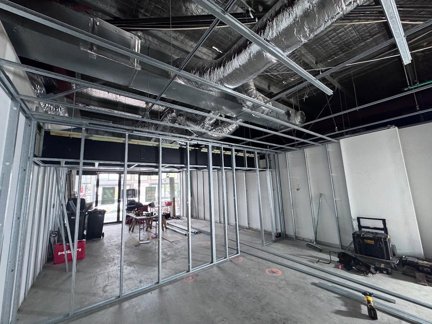 Unfinished interior with exposed metal framing, ductwork, and construction materials on the floor