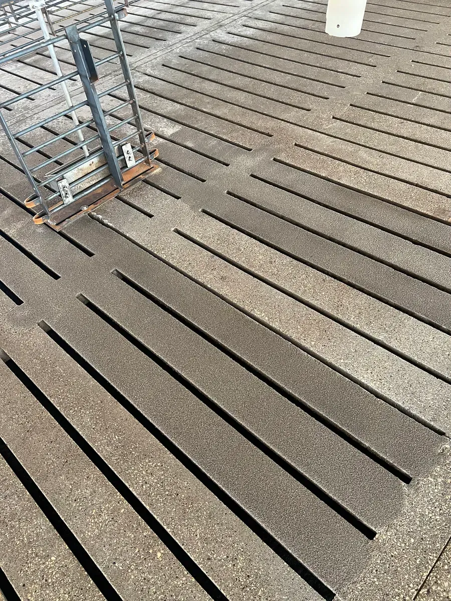 A close up of a concrete floor with a staircase in the background.
