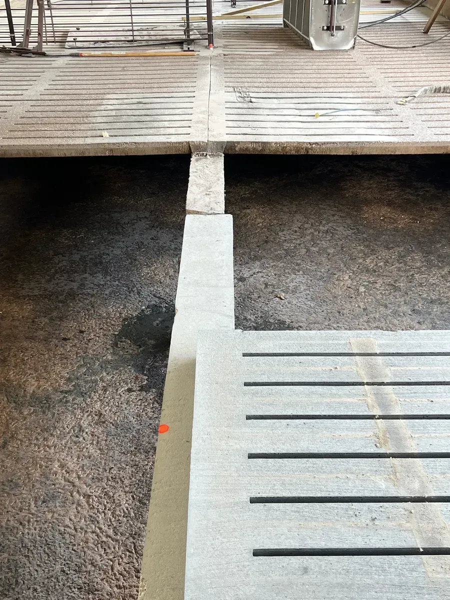 A concrete floor with a wooden floor in the background