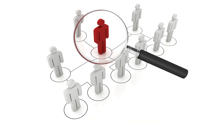 A magnifying glass is looking at a group of people