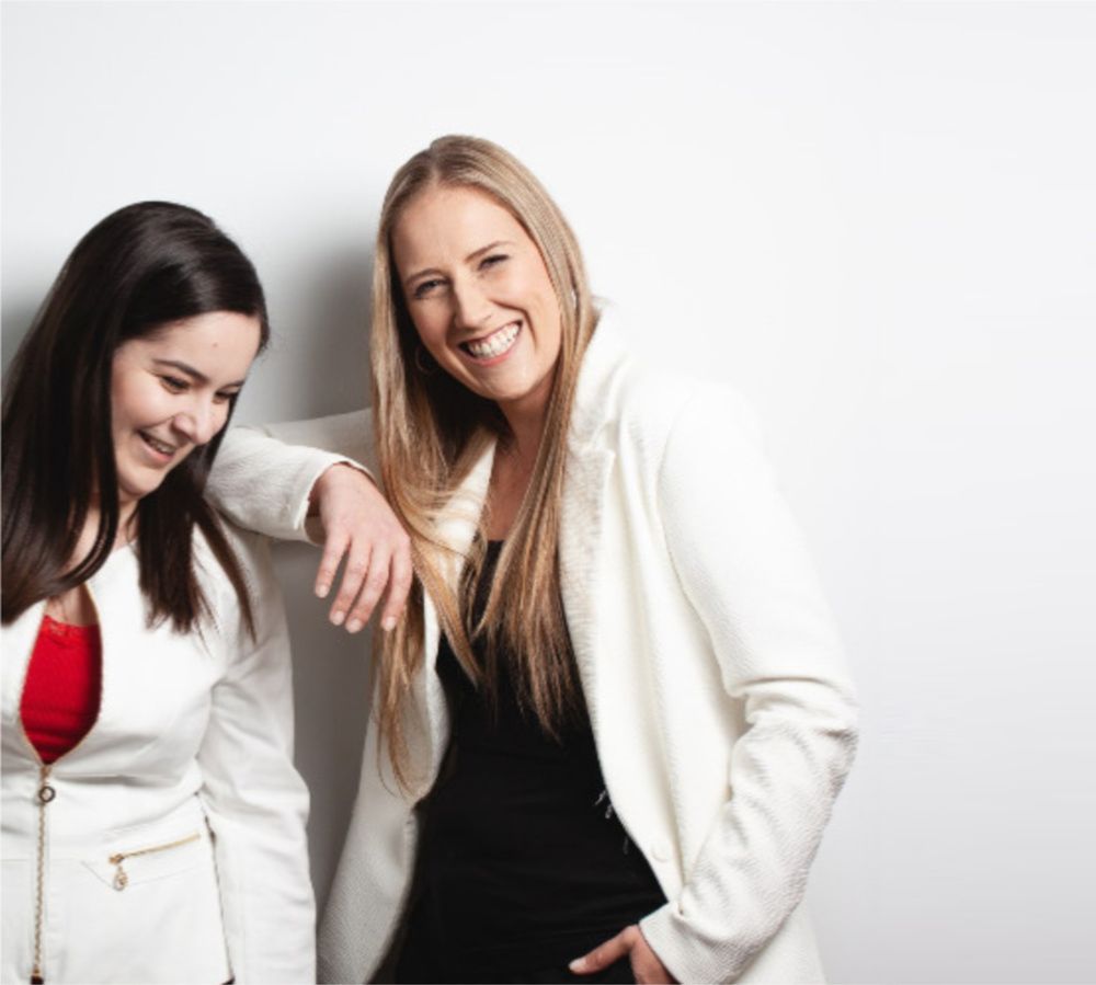 Two women are standing next to each other and smiling