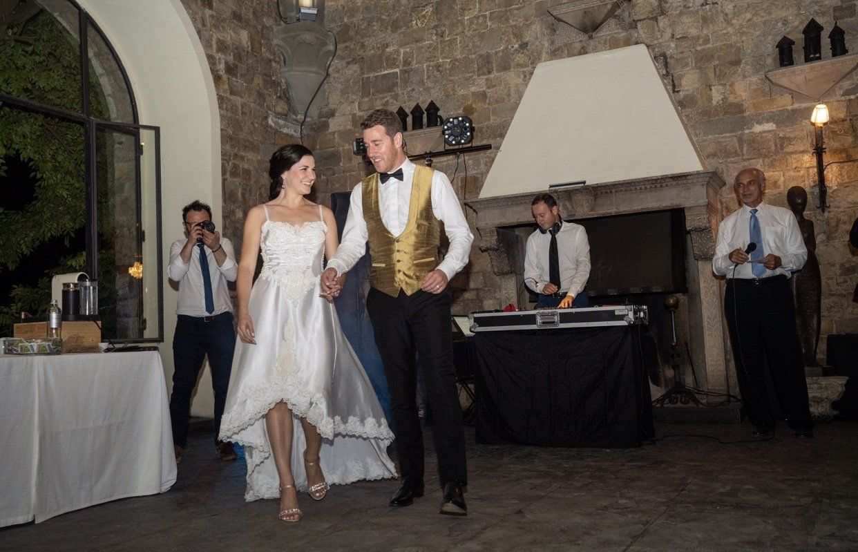 Bride and groom dancing at a reception in a rustic stone-walled venue