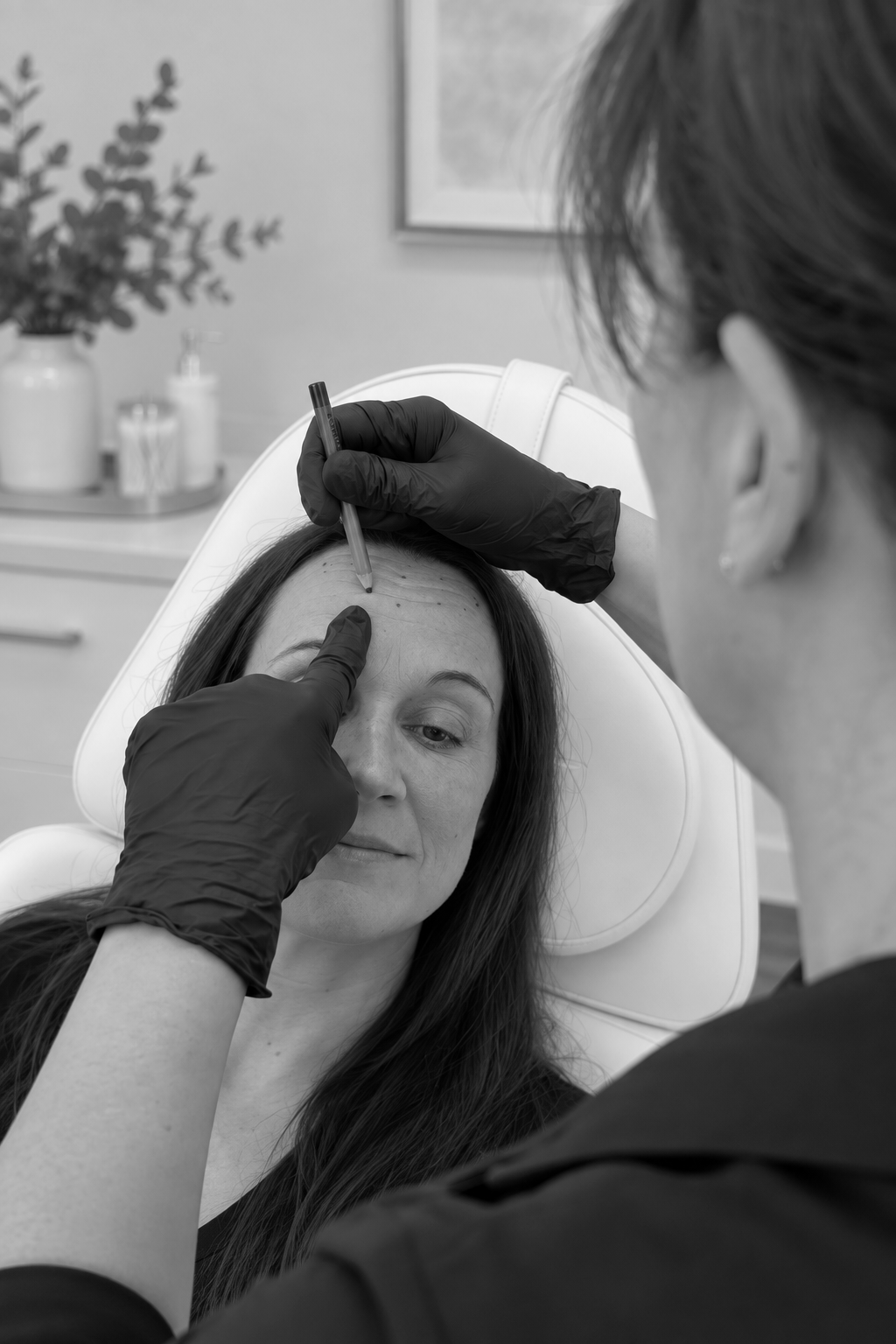Nurse practitioner applying eyebrow treatment to a client in a spa chair