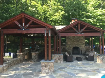 A wooden pavilion with a fireplace in the middle of it