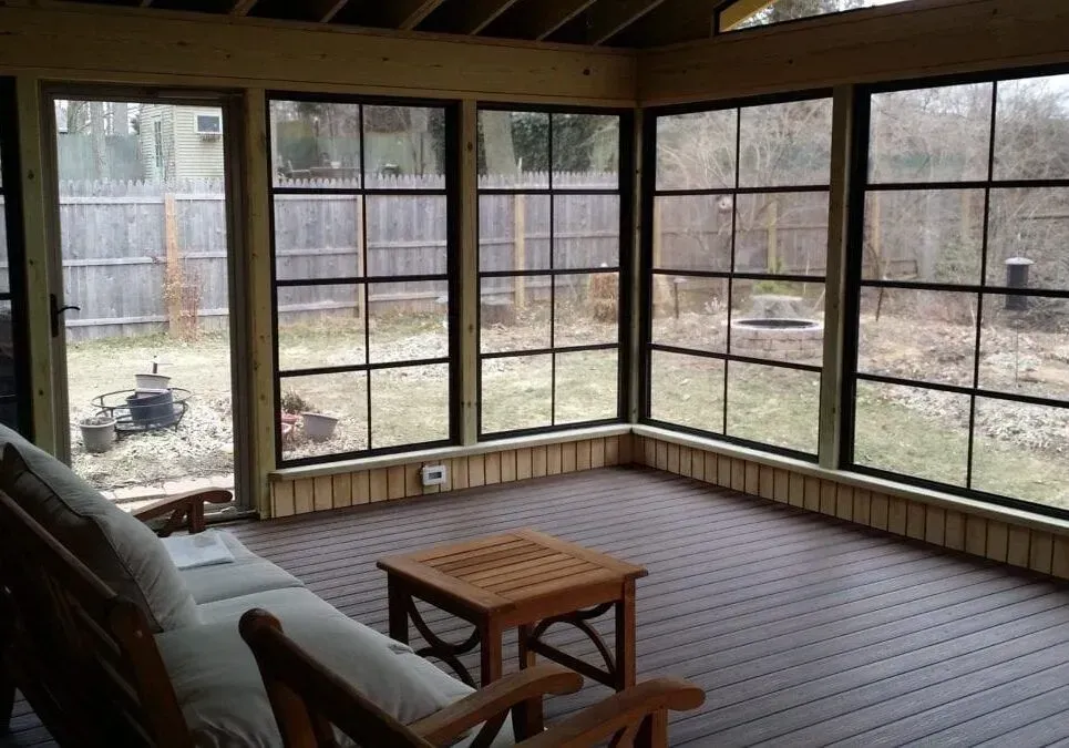 A screened in porch with a couch and chairs