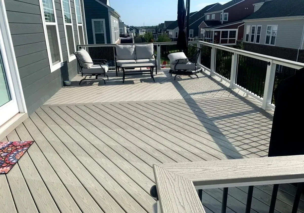 A large deck with a couch and chairs on it