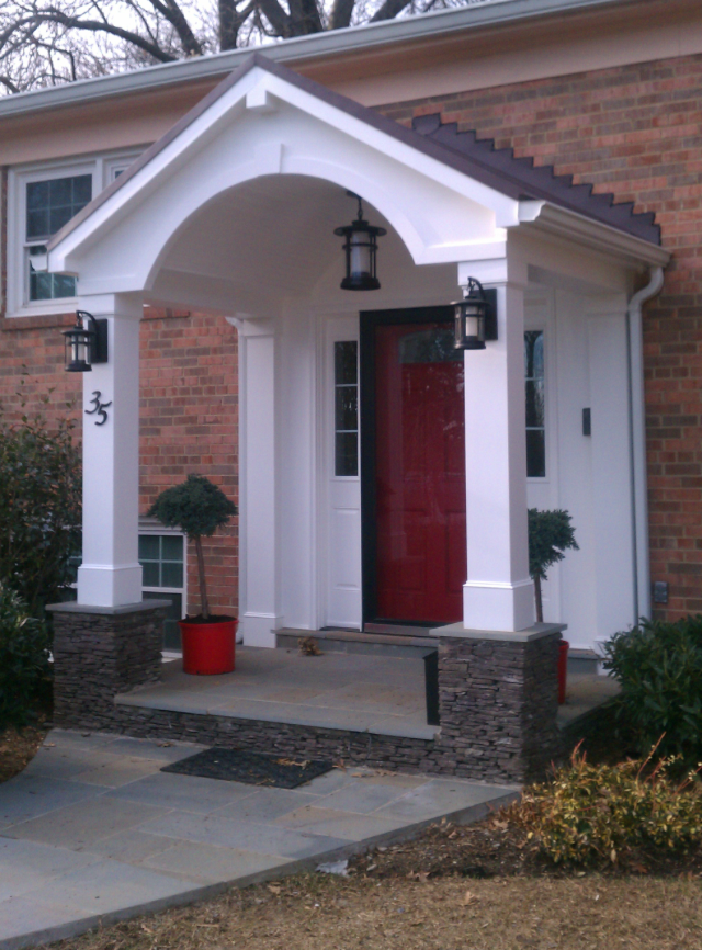 A house with a red door and a porch with the number 5 on it
