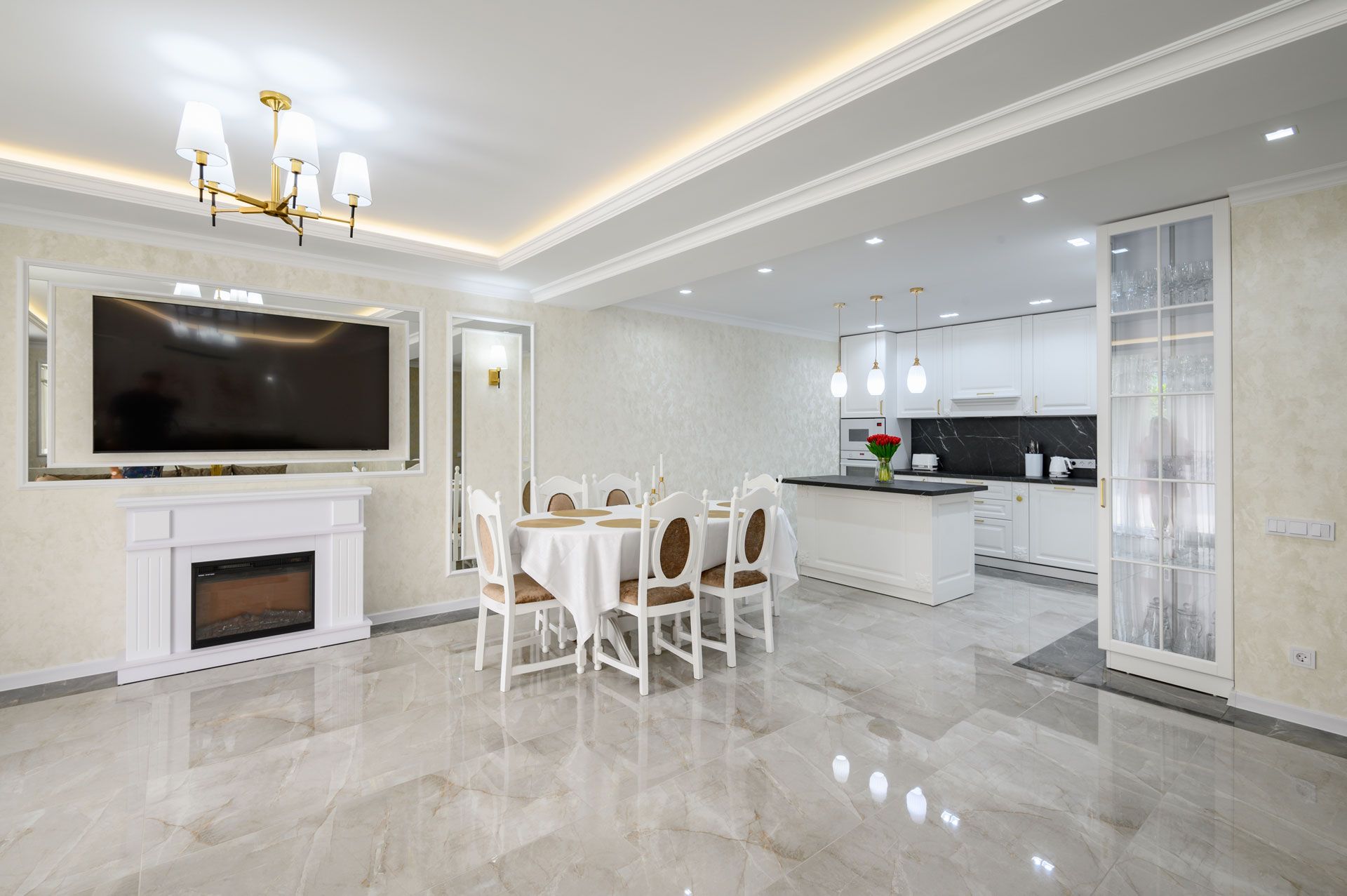 Spacious, modern living space with marble floors, a dining area, and a white kitchen in the background.
