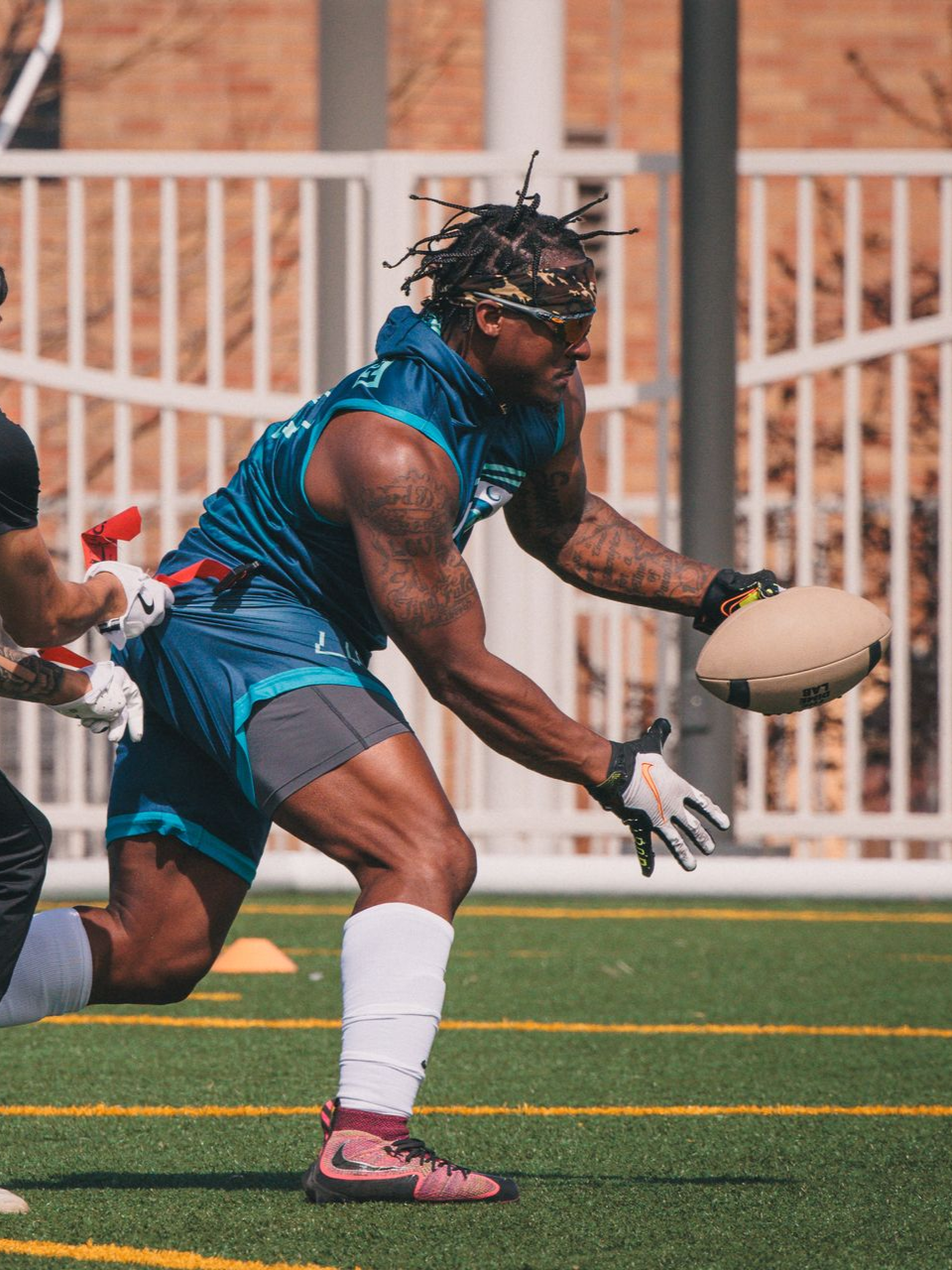 Male flag football player running with the ball during a game.