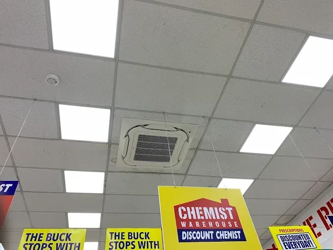 Retail store ceiling with fluorescent lights and sale signs below