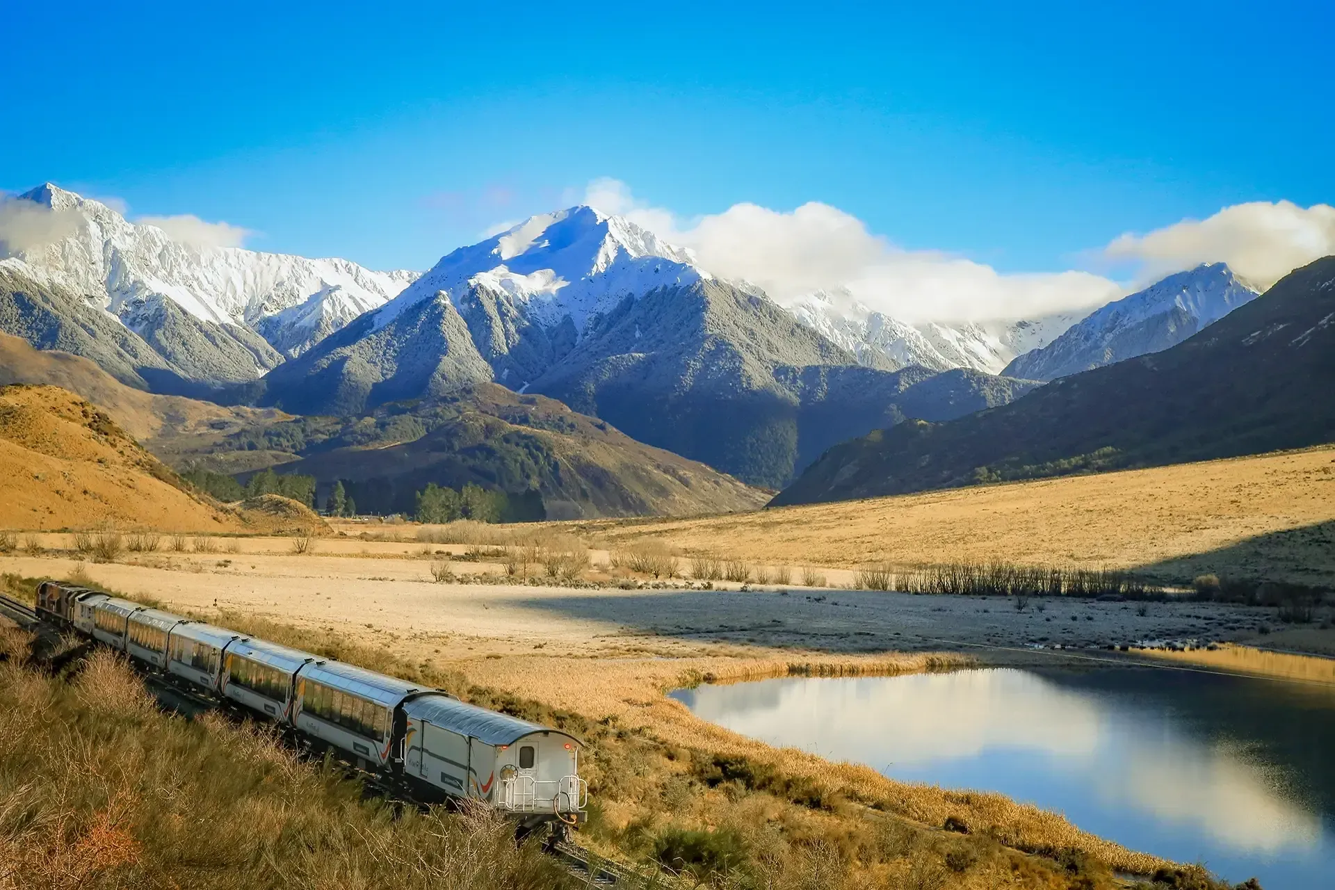 TranzAlpine train passing Lake Sarah in winter