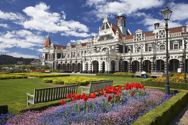 Dunedin Railway Station behind flower beds in full bloom