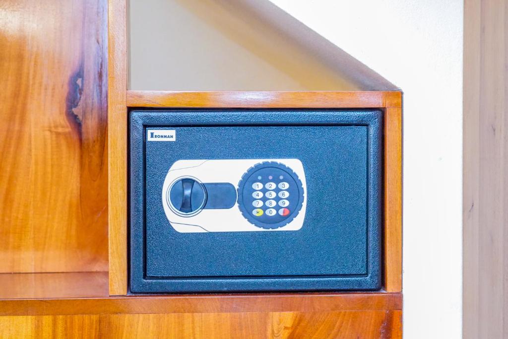 Black safe with digital keypad built into wooden cabinet.