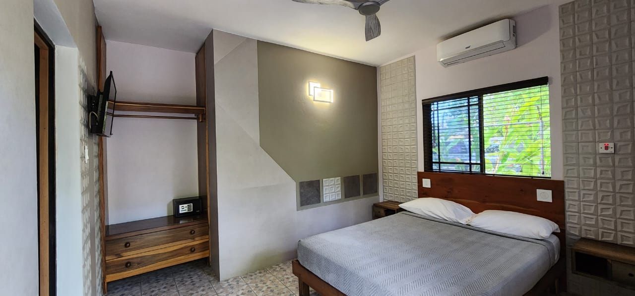 Bedroom with bed, closet, and window; gray and brown color scheme.