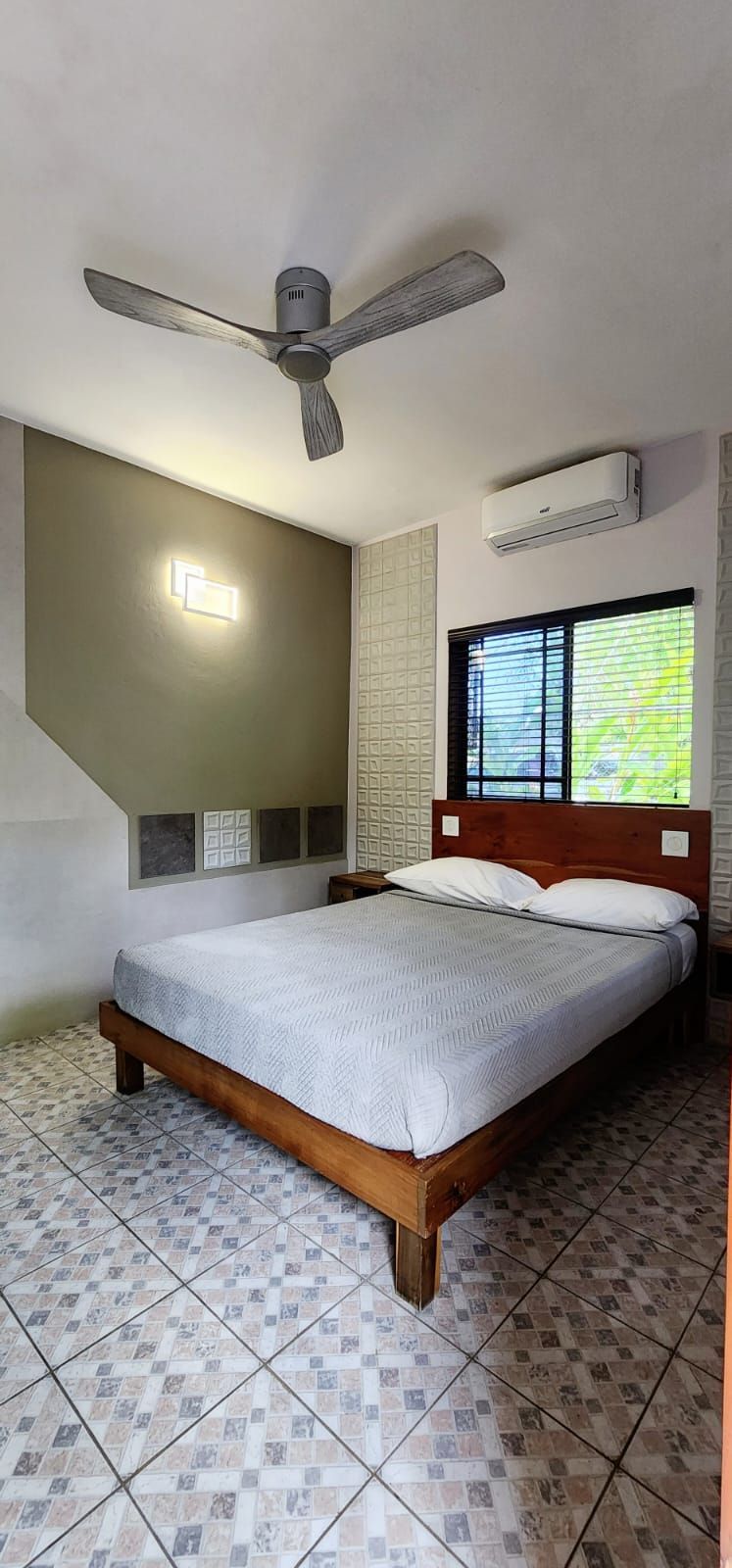 Bedroom with a bed, ceiling fan, air conditioner, and tiled floor.