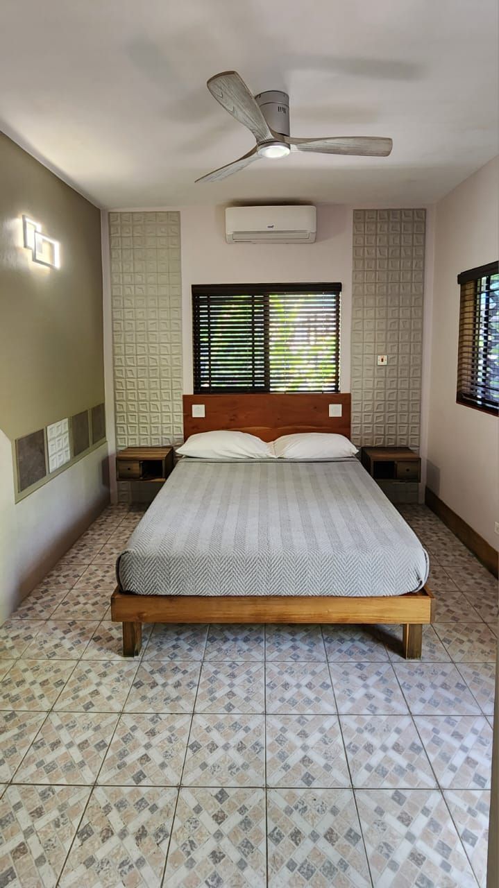 Bedroom with a bed, nightstands, decorative panels, and a ceiling fan.