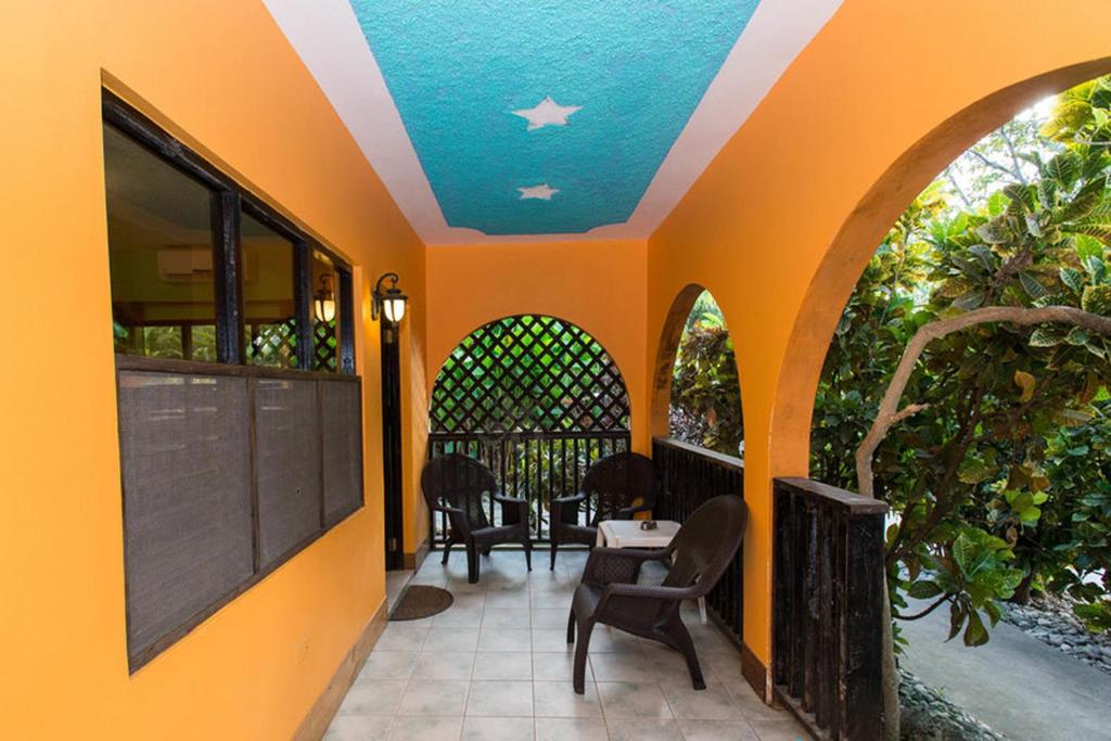 Orange and blue veranda with outdoor furniture, and a decorative trellis.