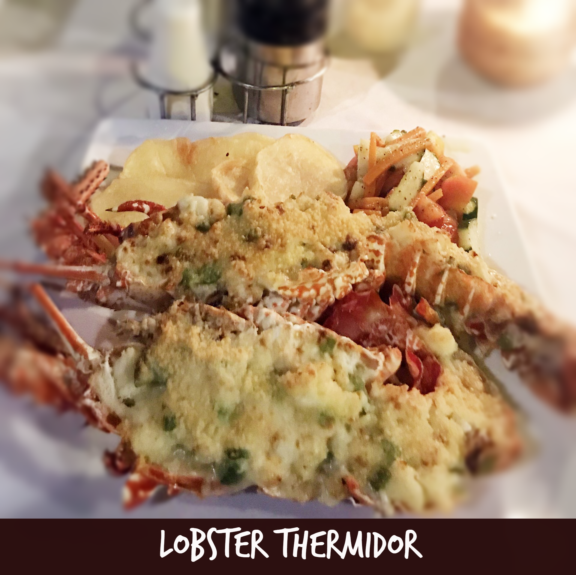 Lobster Thermidor on a plate with potato chips and vegetables; close-up shot.