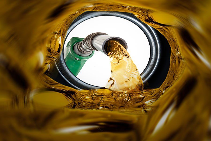 Gasoline pouring from fuel nozzle into car tank during refueling