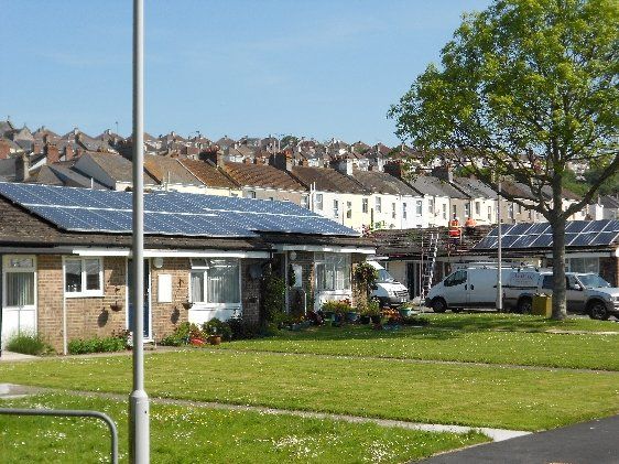 Apollo Electrical Solutions | A row of houses with solar panels on the roofs