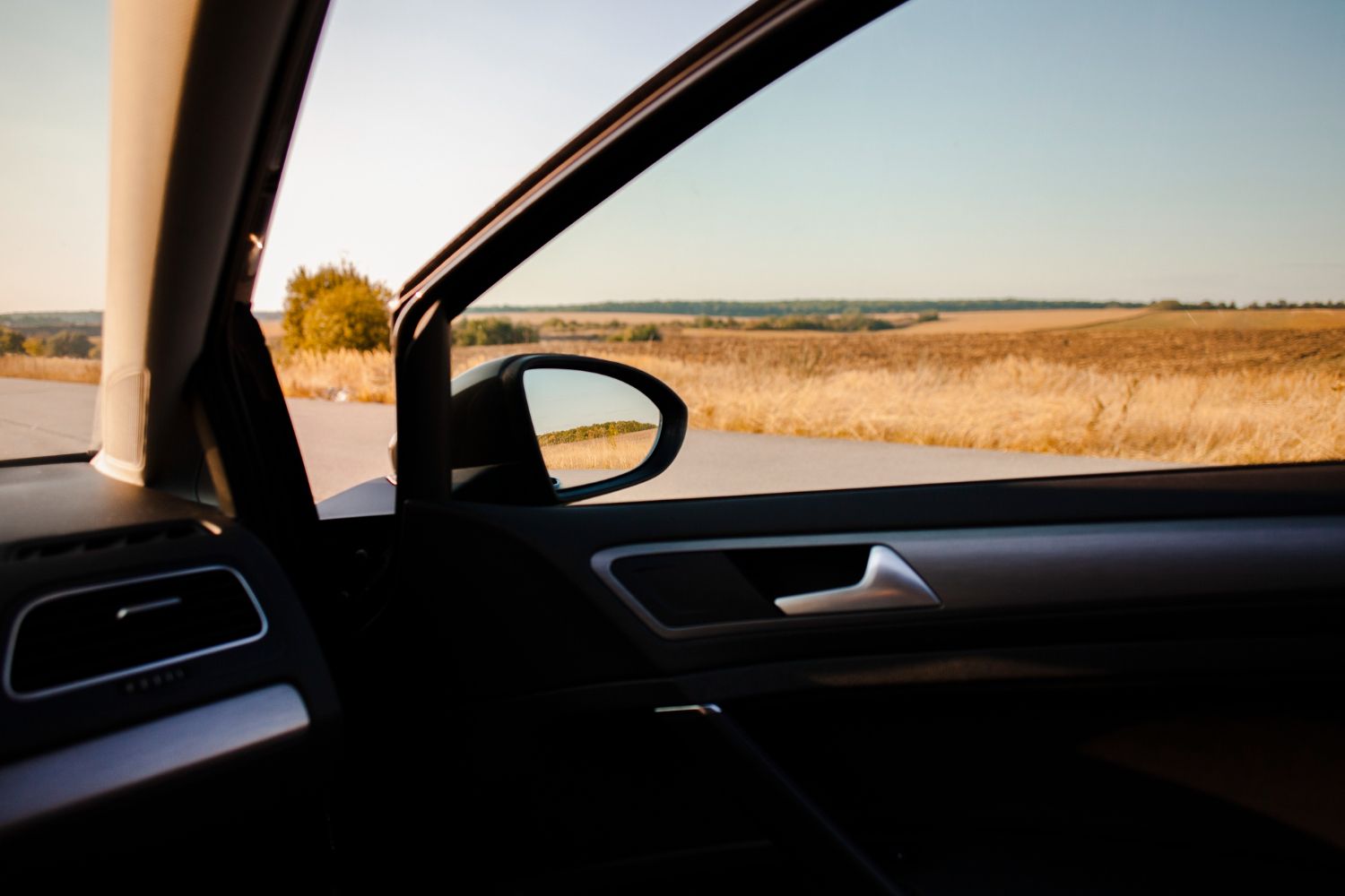 A car is parked on the side of the road and looking out the window.