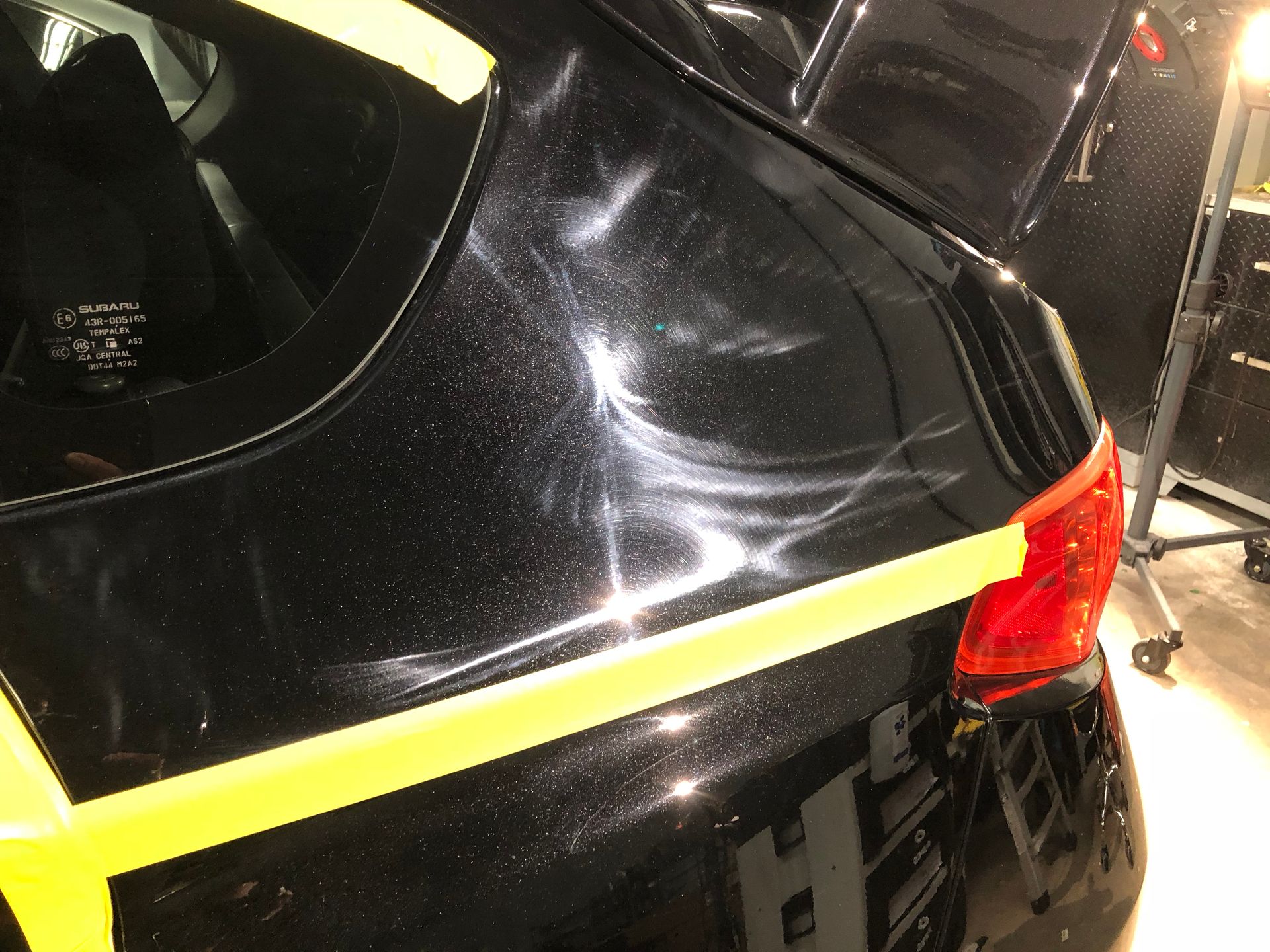 A close up of a black car with yellow tape on it