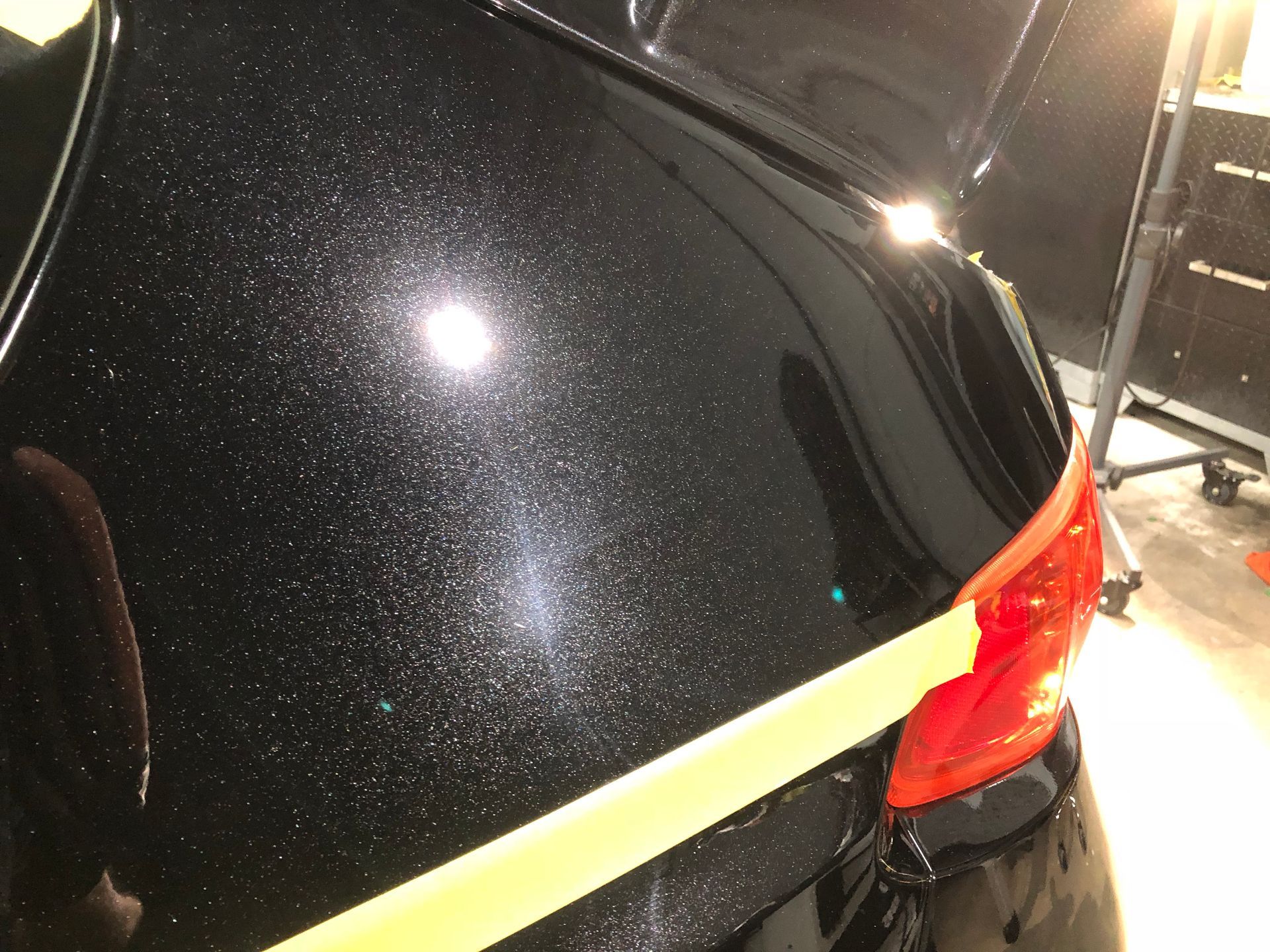 A close up of a black car with yellow tape on it