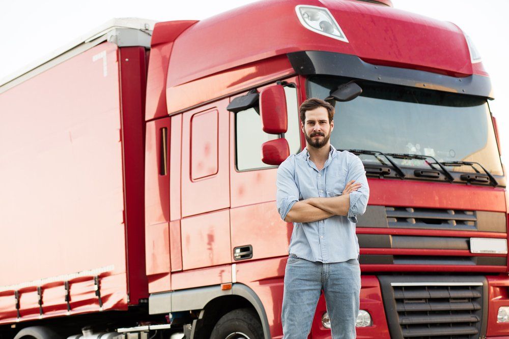 Man Standing In Front Of Red Truck — Reliable Driver Training in Darwin