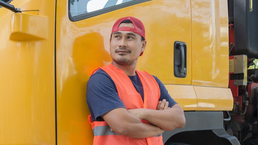 Person Leaning Against Yellow Truck — Reliable Driver Training in Darwin, NT