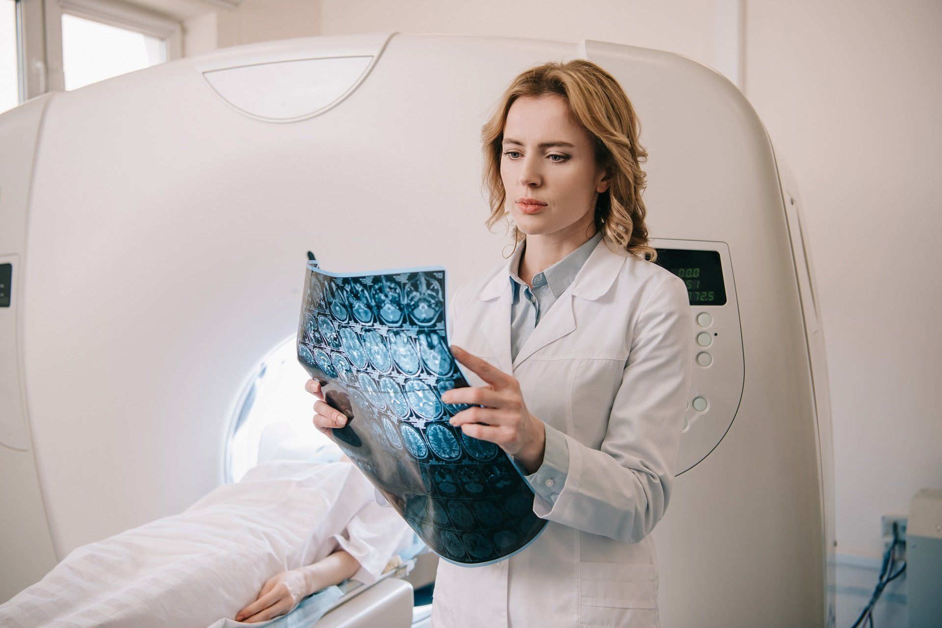 Doctor examining scan in front of a CT scanner. Stroke Misdiagnosis 
