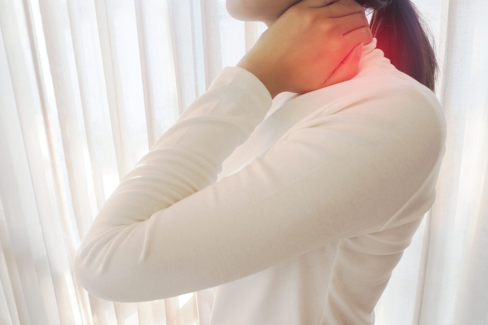 Woman holding her neck, indicating pain -  Understanding Spinal Epidural Abscesses