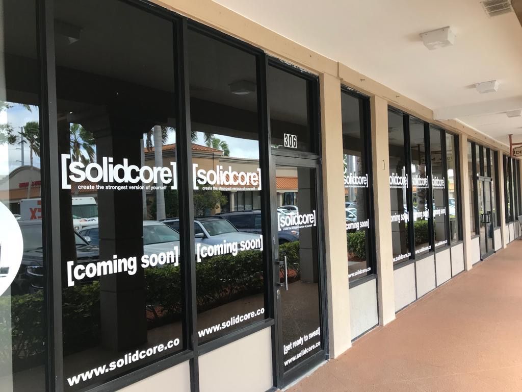 Exterior of a storefront with windows, the sign reads