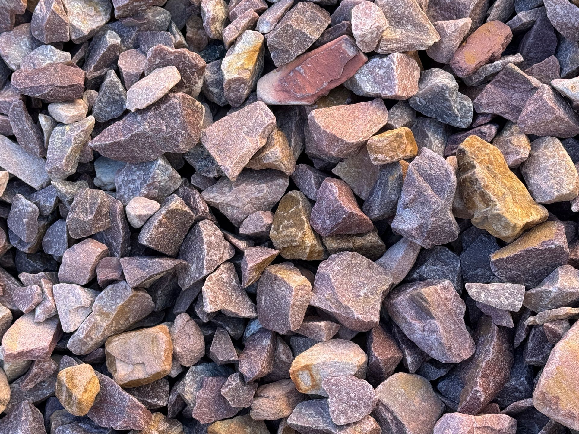 White golf ball on reddish gravel rocks.