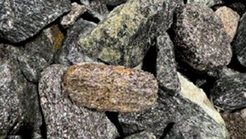Pile of rough, multicolored rocks and stones stacked closely together.