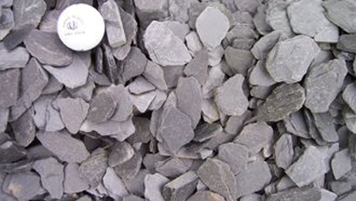 Pile of gray rocks with a white bottle cap at the top left