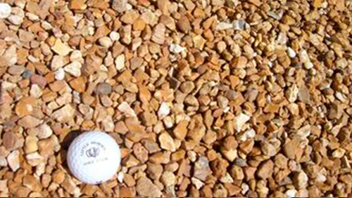 White plastic cap on tan gravel stones