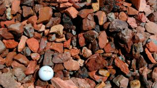 White golf ball on red-brown rocks