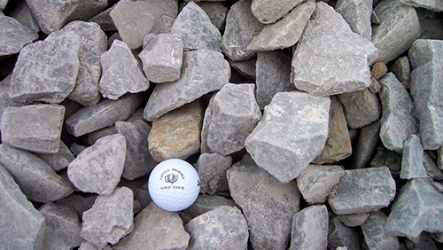 Pile of gray rocks with a white golf ball near the center