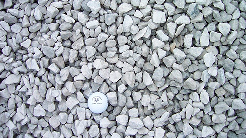 White gravel with a small white round object near the bottom center
