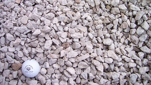 White golf ball on light-colored gravel stones