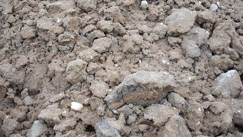 Close-up of dry, rocky dirt with small stones and clumps of soil