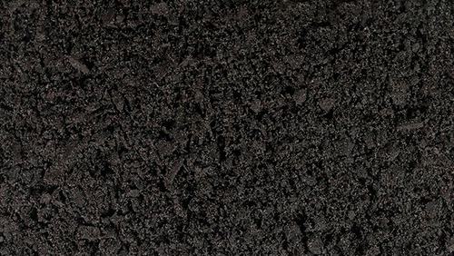 Dark, grainy textured surface with mottled black and gray pattern