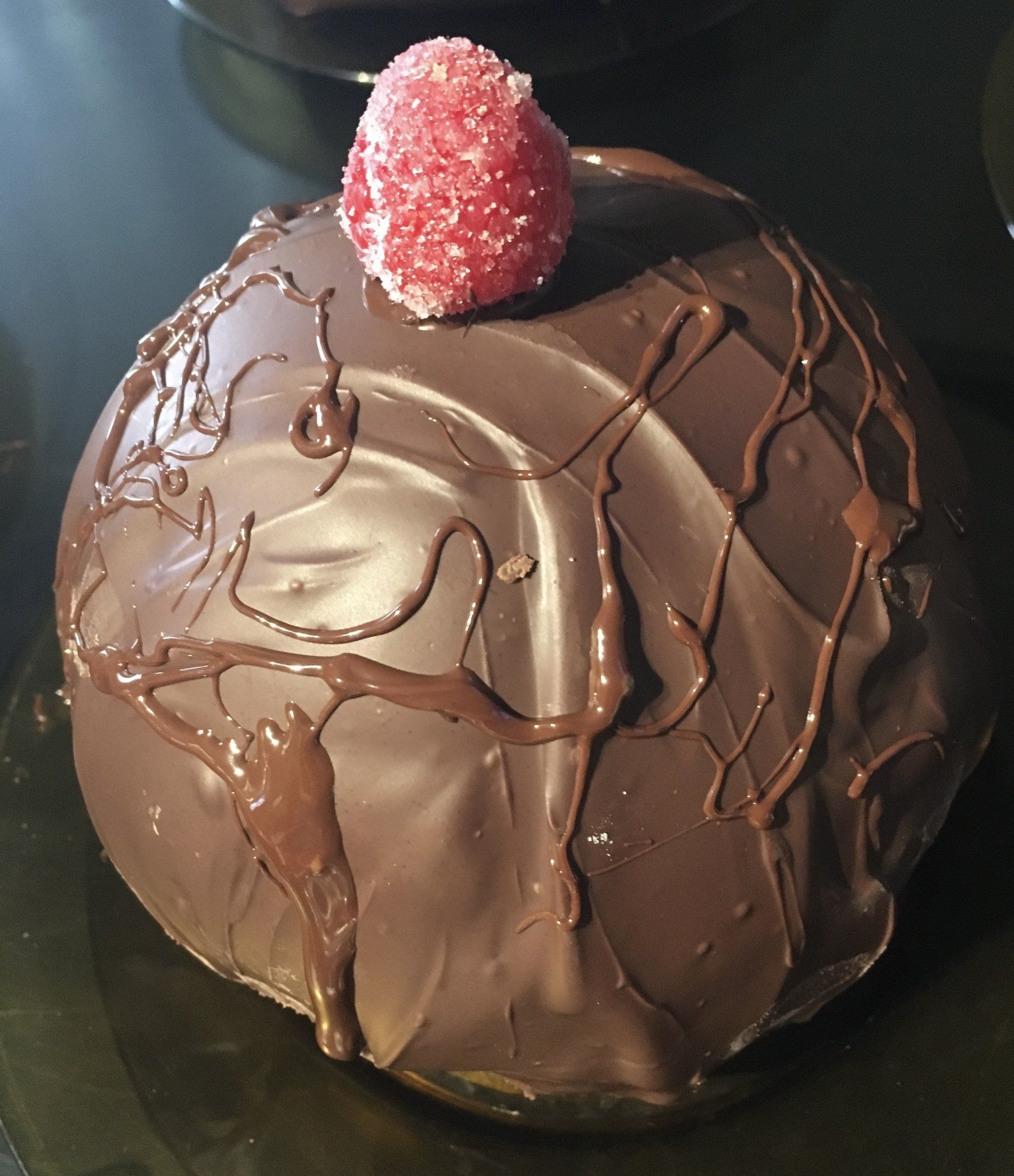 A chocolate cake with a raspberry on top