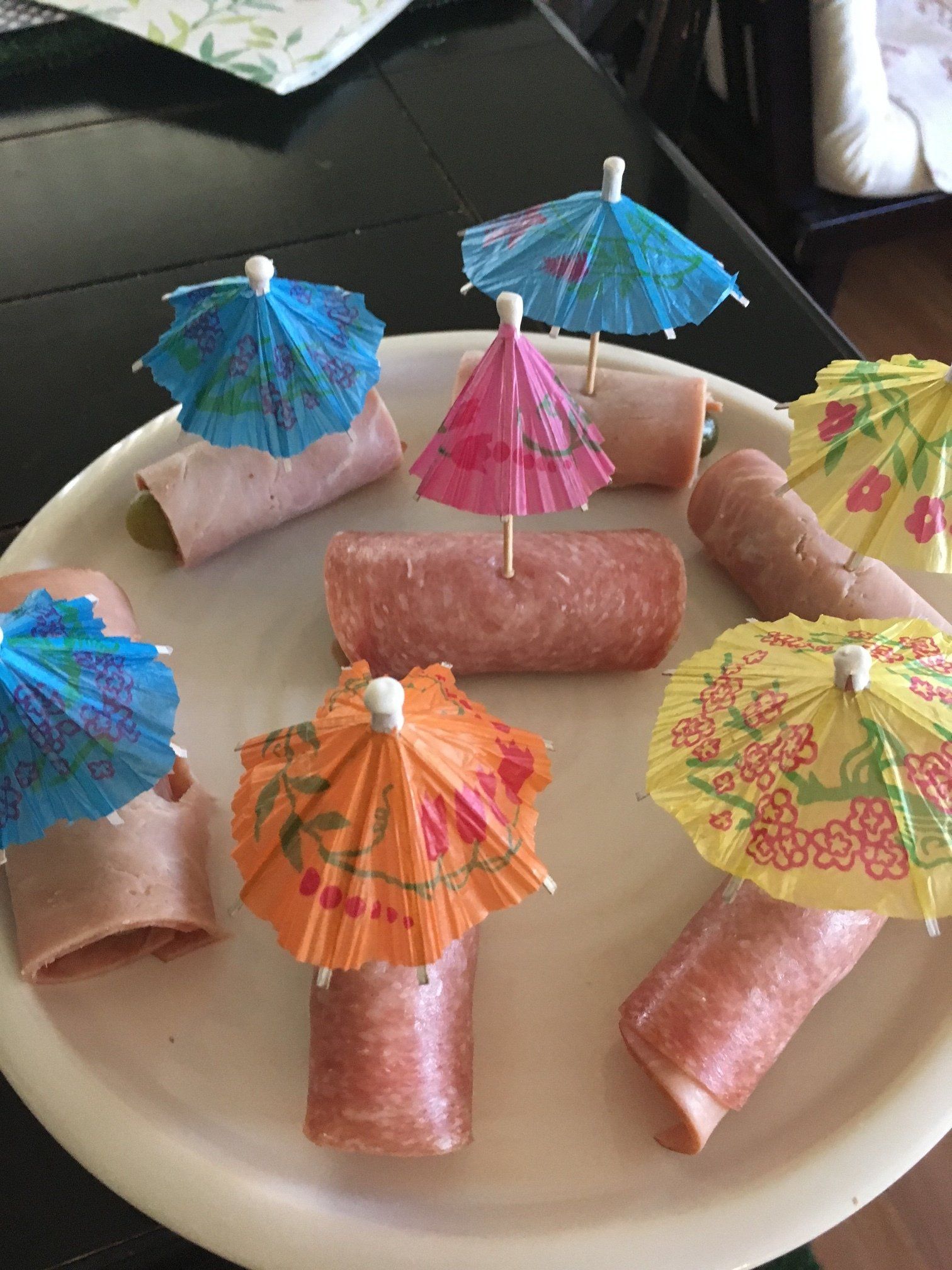 A plate of food with umbrellas on it on a table.
