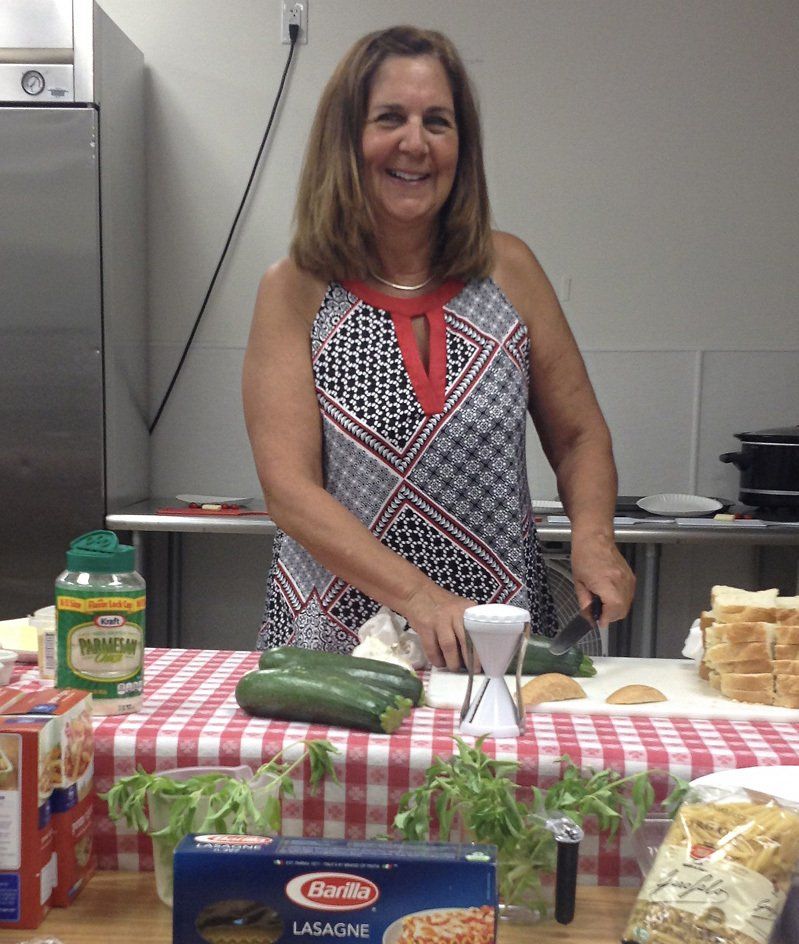 A woman standing in front of a table with a box of barilla lasagna on it